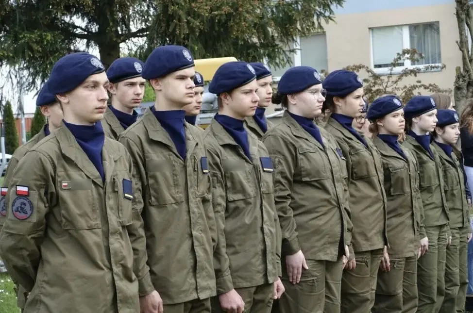 Kadeci oddziału przygotowania wojskowego w mundurach i granatowych beretach, w szeregu podczas uroczystości