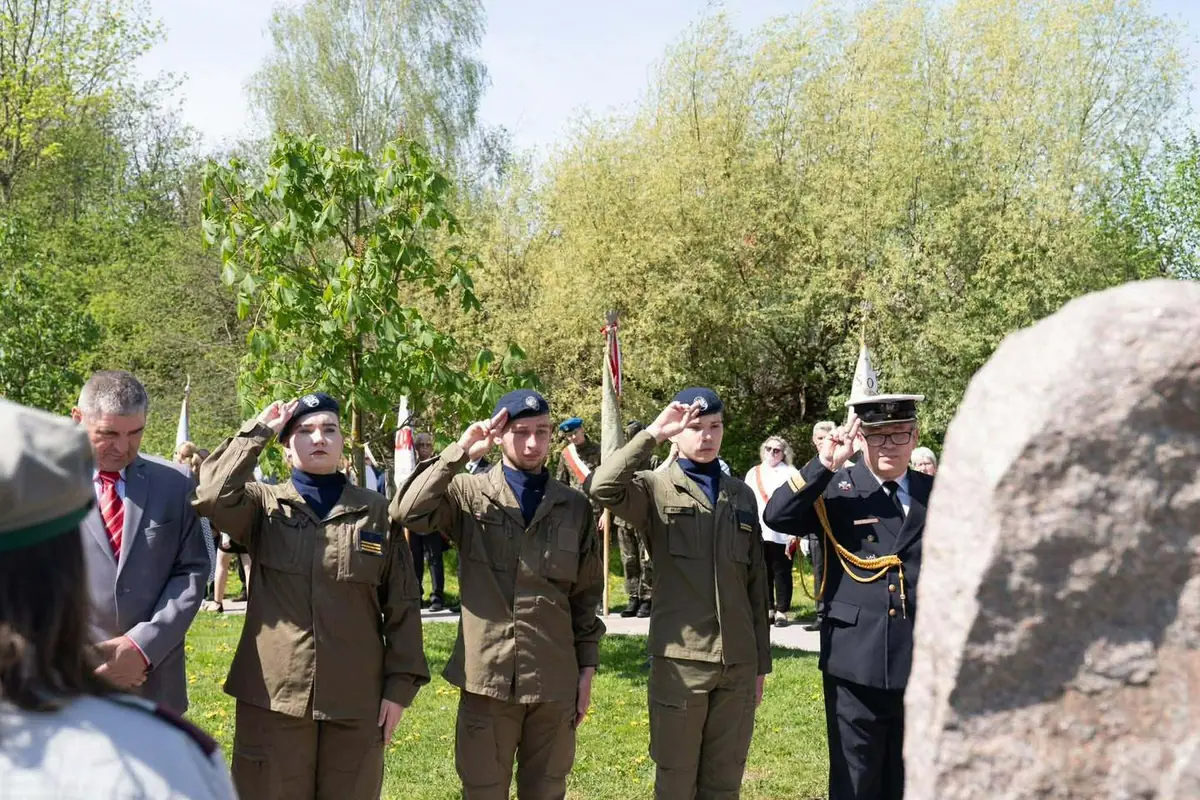 Delegacja kadetów salutuje obok kamiennego pomnika podczas obchodów 3 Maja